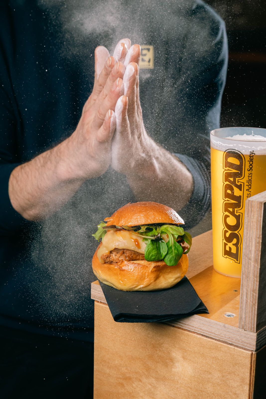 Le chef frappe dans ses mains au-dessus d'un burger
